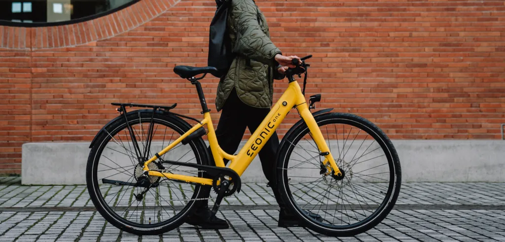 Gelbes E-Bike von Eonic auf der Straße mit Fahrer – Beispiel für die richtige Sitzposition laut E-Bike Rahmenhöhenrechner